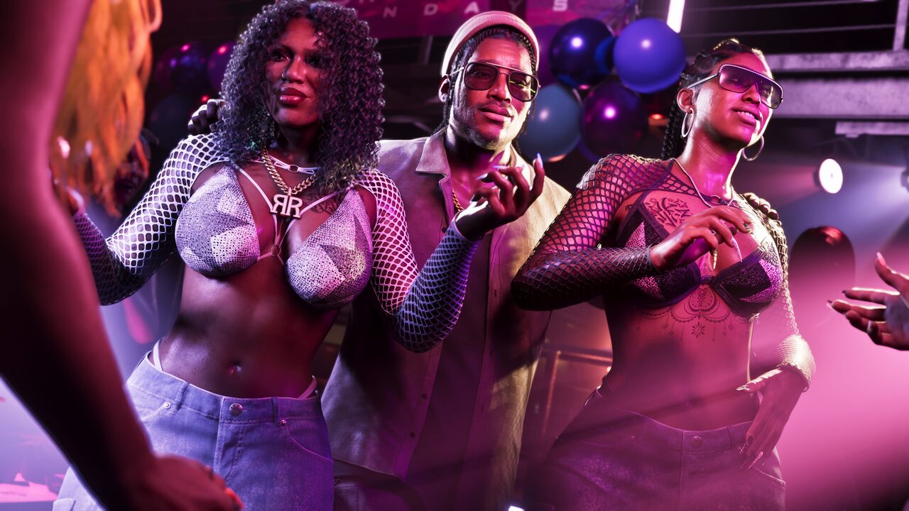 Dre'Quan Priest at a party under stage lighting, flanked by two other figures.