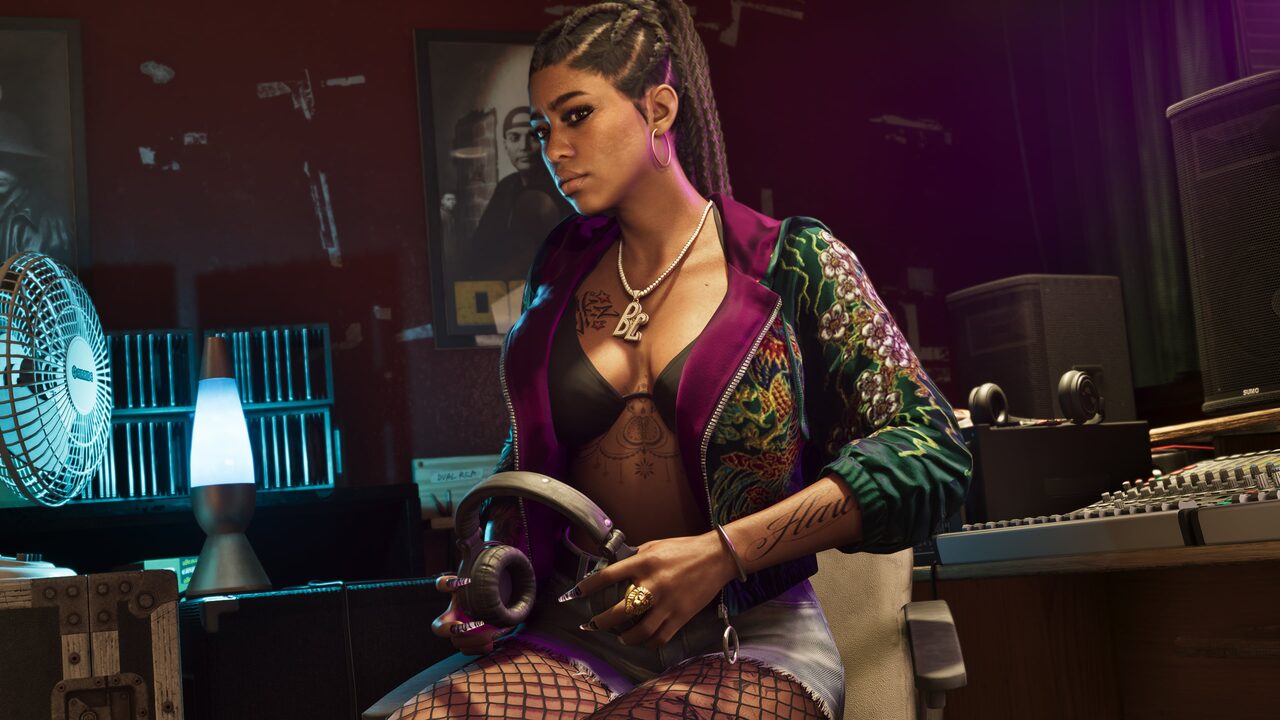 A woman with long braids and a gold BL pendant sitting in a recording studio holding headphones, with a mixing desk, speakers and a lava lamp around her.