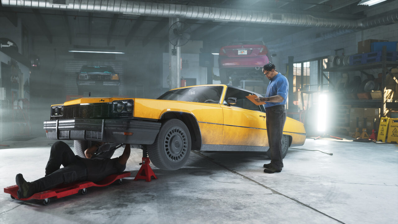 A yellow Albany sedan on axle stands in a workshop, one mechanic underneath on a creeper while another checks a clipboard.