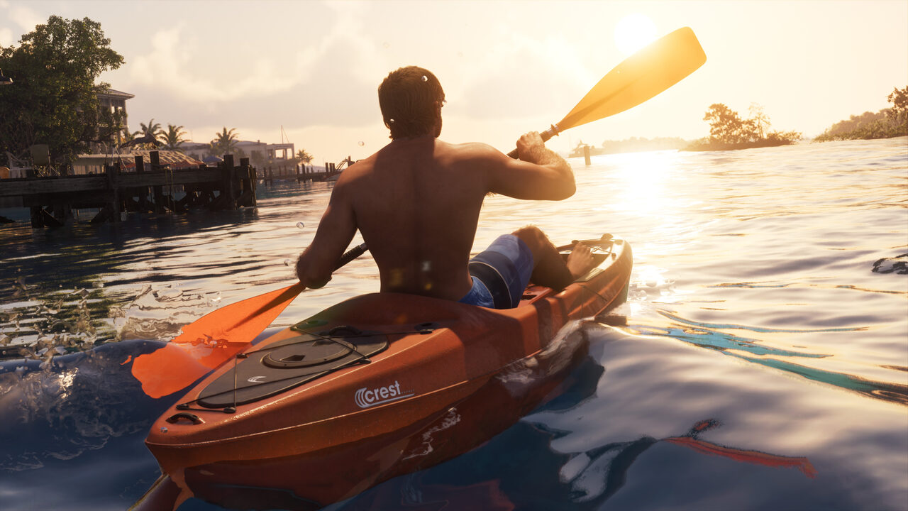 A man paddling an orange kayak on calm water at sunrise, a stilt house and jetty on the shore behind him.