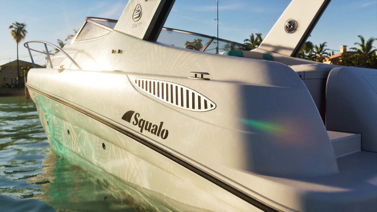 Close side detail of a white Squalo speedboat hull with its name and Shitzu badge, moored in shallow sunlit water beside palms.
