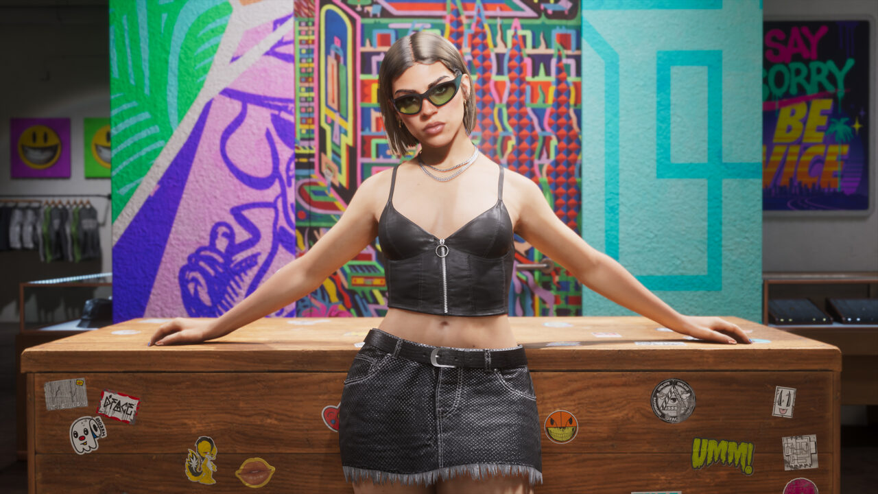 A woman in sunglasses, a black leather bustier and denim skirt leaning back against a sticker-covered counter in a brightly muralled store.