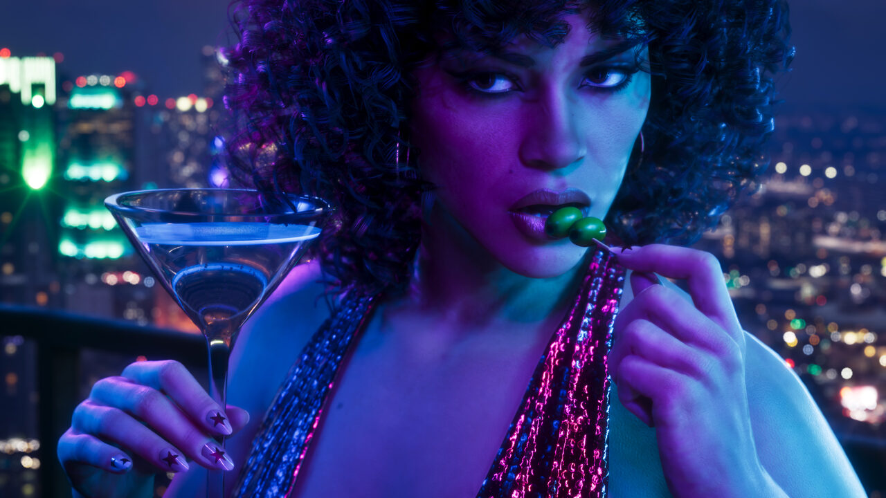A woman with curly hair in a sequin top biting an olive from a martini, a city at night behind her.