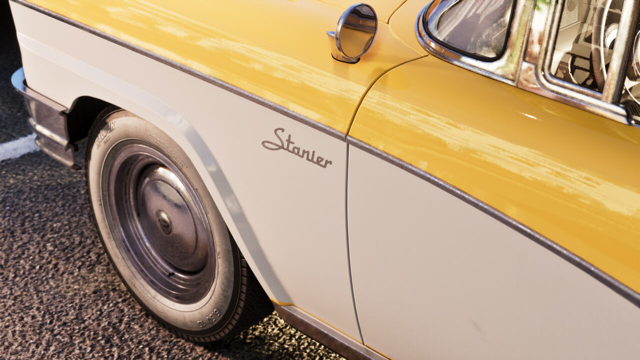 Close detail of a yellow and white Stanier sedan: a whitewall tyre and the chrome Stanier script on its side.